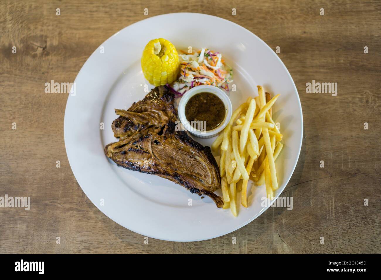 Juicy lamb chop grill to perfection with barbeque sauce, french fries, corn and coleslaw as side