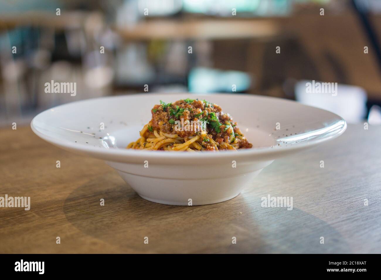 Plate of delicious spaghetti Bolognaise or Bolognese with savory minced beef and tomato sauce garnished with parmesan cheese. Stock Photo