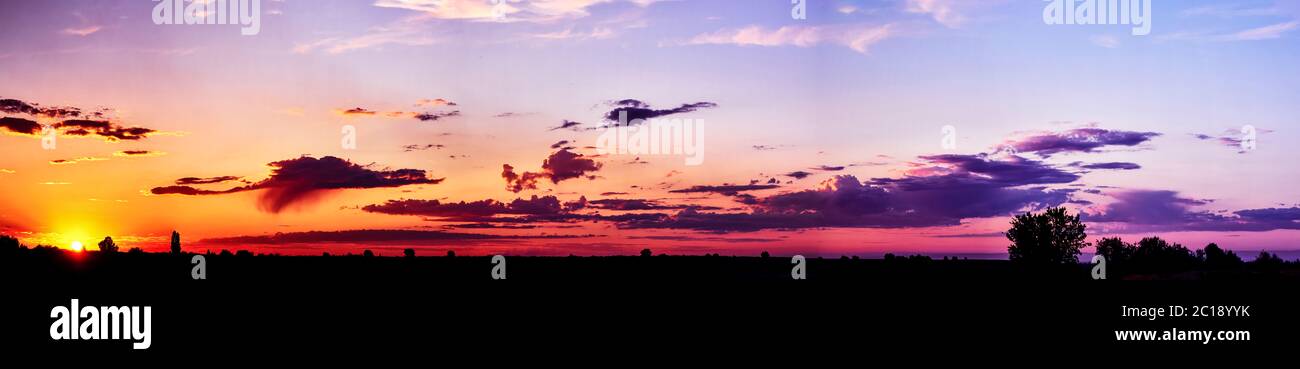 Bright sunlight through the clouds against a breathtaking evening sky at sunset. panorama, natural composition Stock Photo