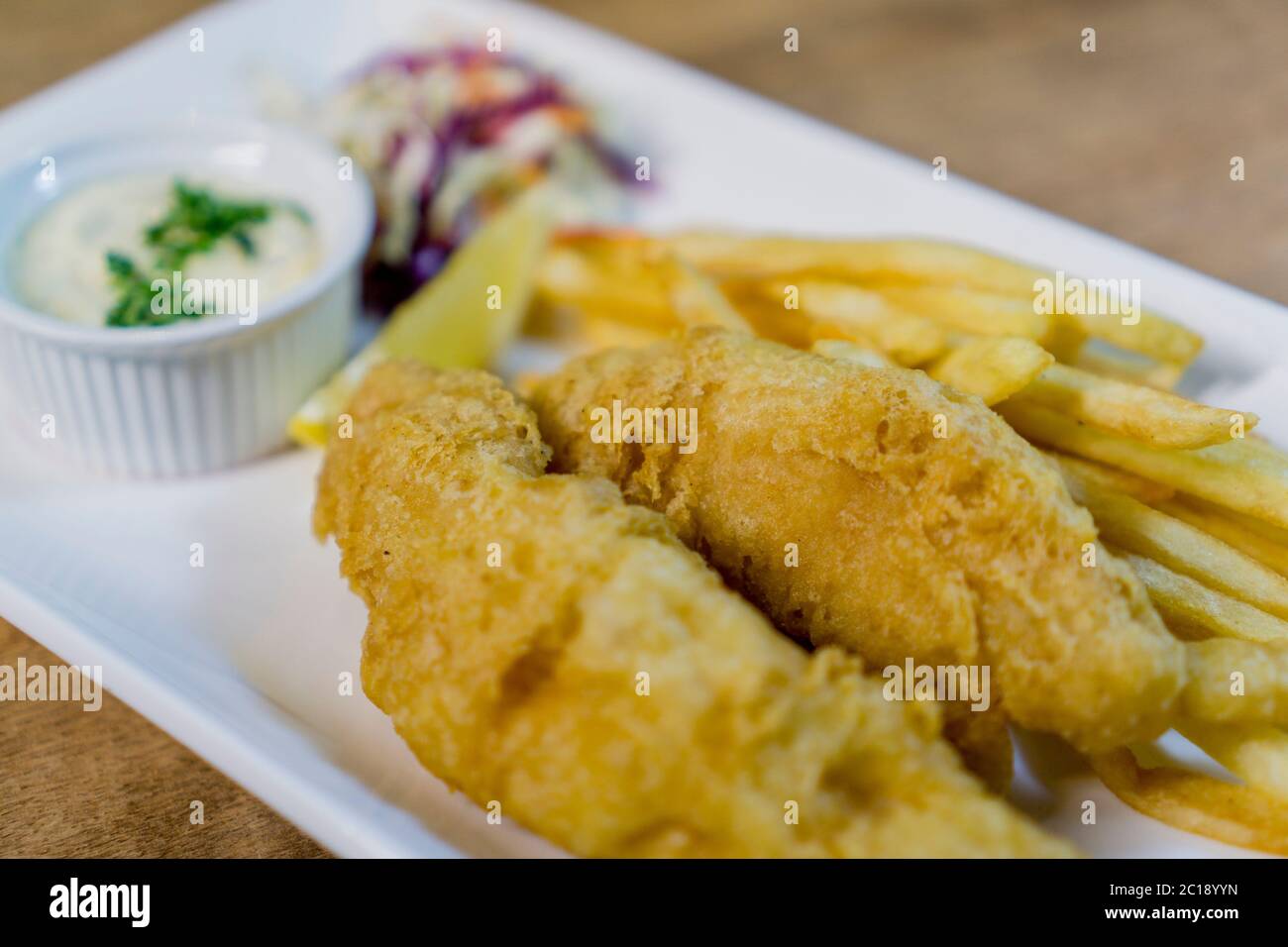 British Traditional fish and chips and tartar sauce and served with coleslaw. Stock Photo