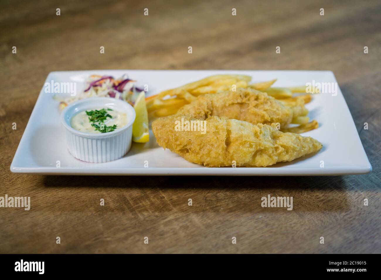 British Traditional fish and chips and tartar sauce and served with coleslaw. Stock Photo