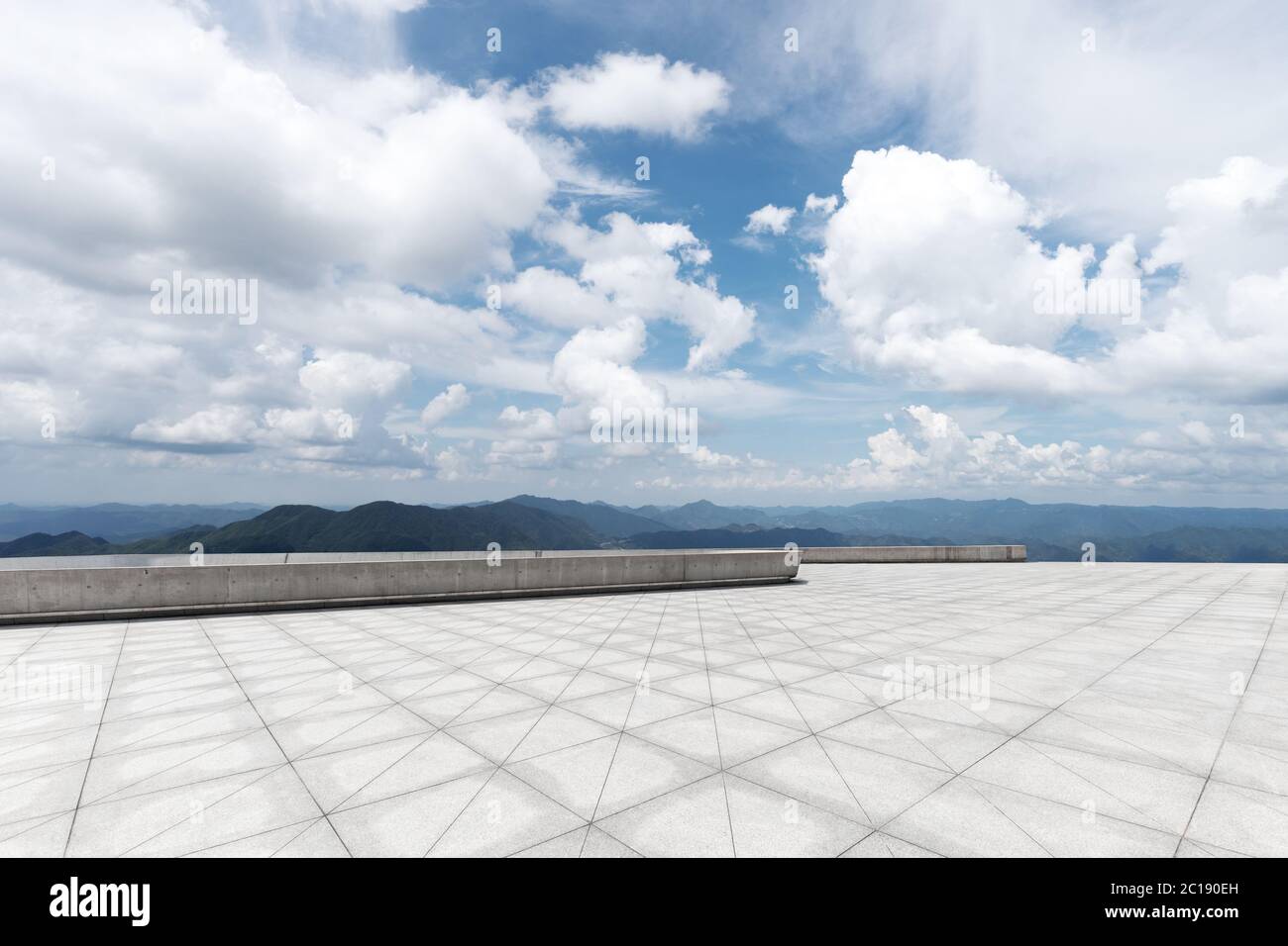 empty marble floor with green hill in cloud sky Stock Photo