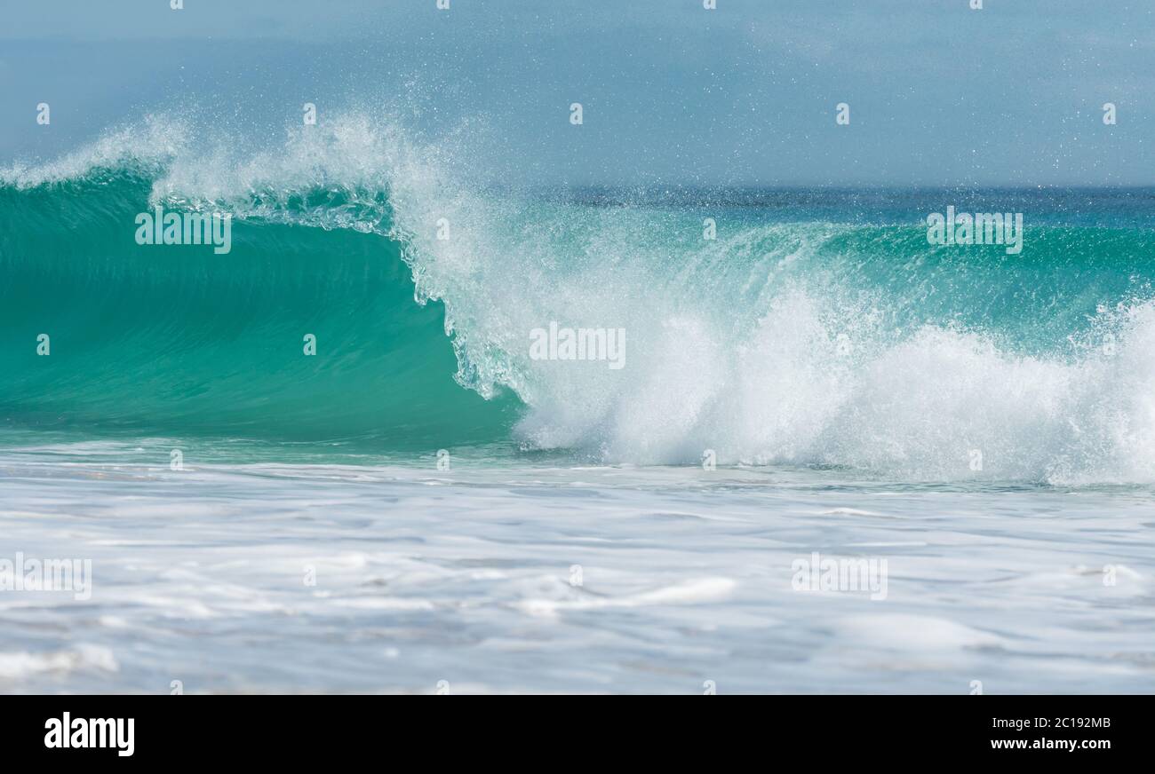 turquoise blue wave breaking or crashing on to the water concept Summer  tropical holiday or vacation Stock Photo