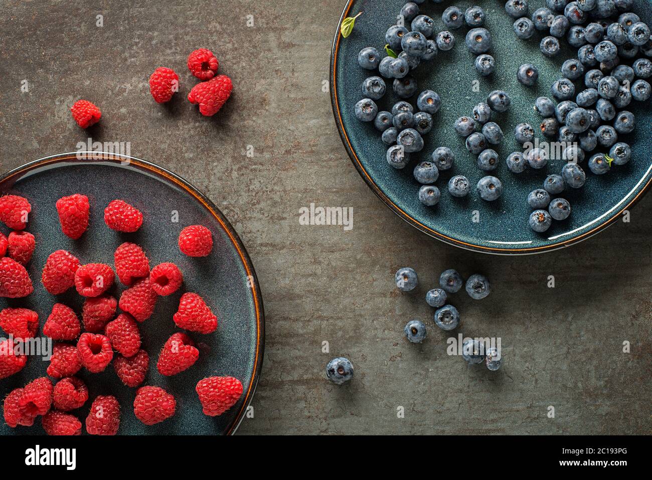 Blueberry Raspberry Size Comparison Colorful assorted of blueberry and raspberry. Berries overhead closeup ...