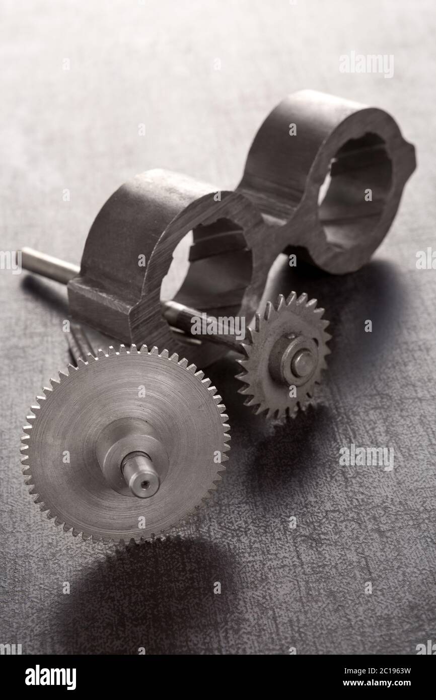 Cogwheels and mechanical component on concrete. Stock Photo