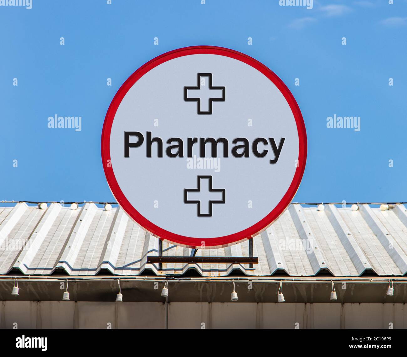 A Circle billboard with text Pharmacy, is installed on a roof. Sign of Drugstore. Stock Photo
