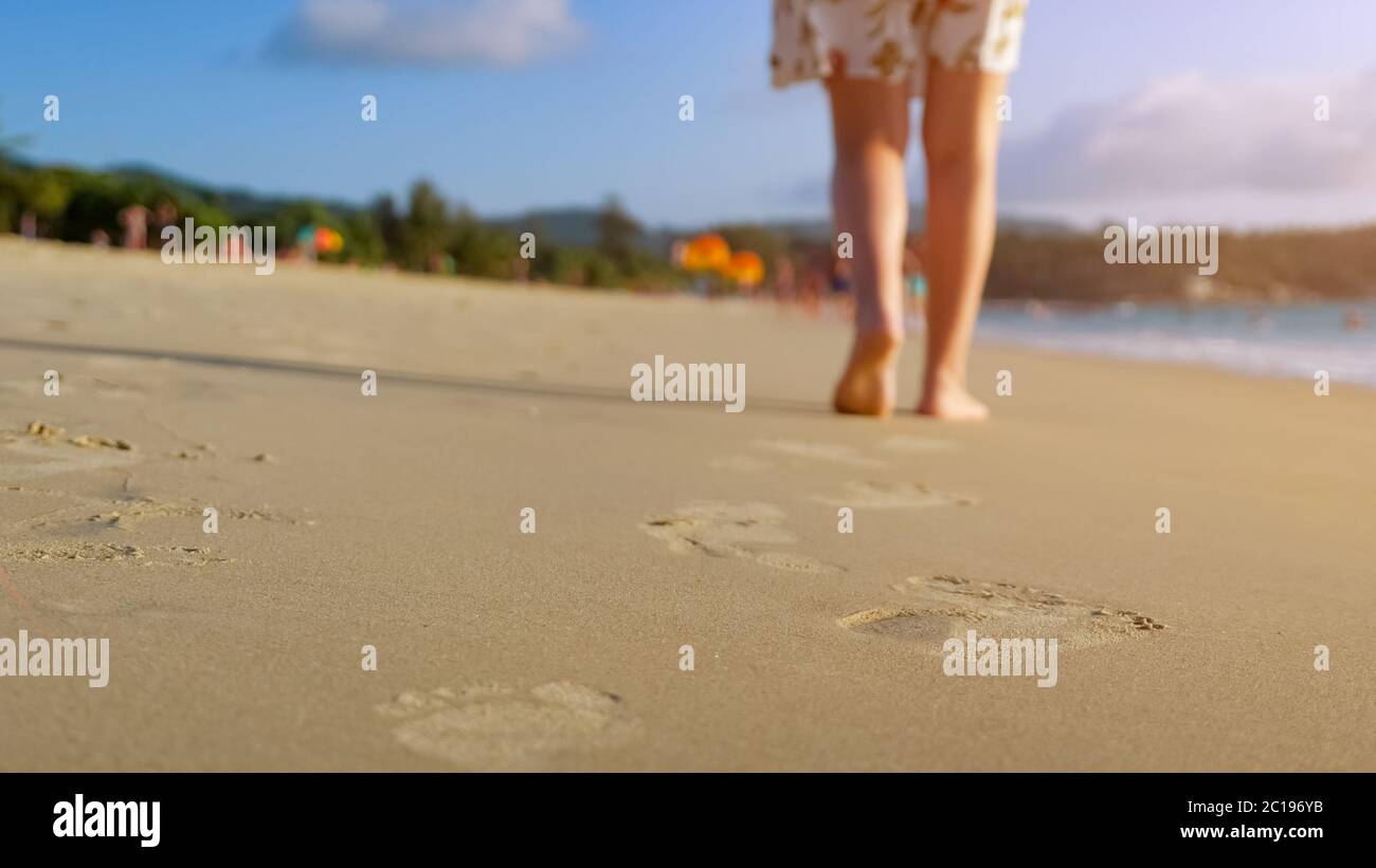 barefoot woman walks on ocean beach wet sand leaving footprints close ...