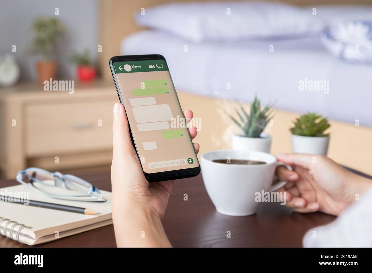 woman hand holding mobile smartphone with mockup screen of chat message on social media application. template of speech bubble dialog box Stock Photo