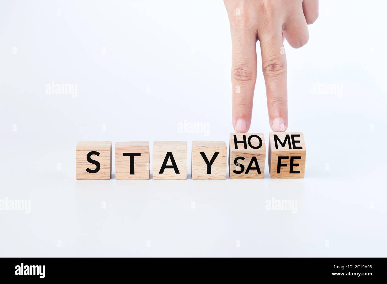 hand flip wooden cube with slogan stay home, stay safe. self isolation, stay home awareness campaign for coronavirus prevention during the covid-19 Stock Photo