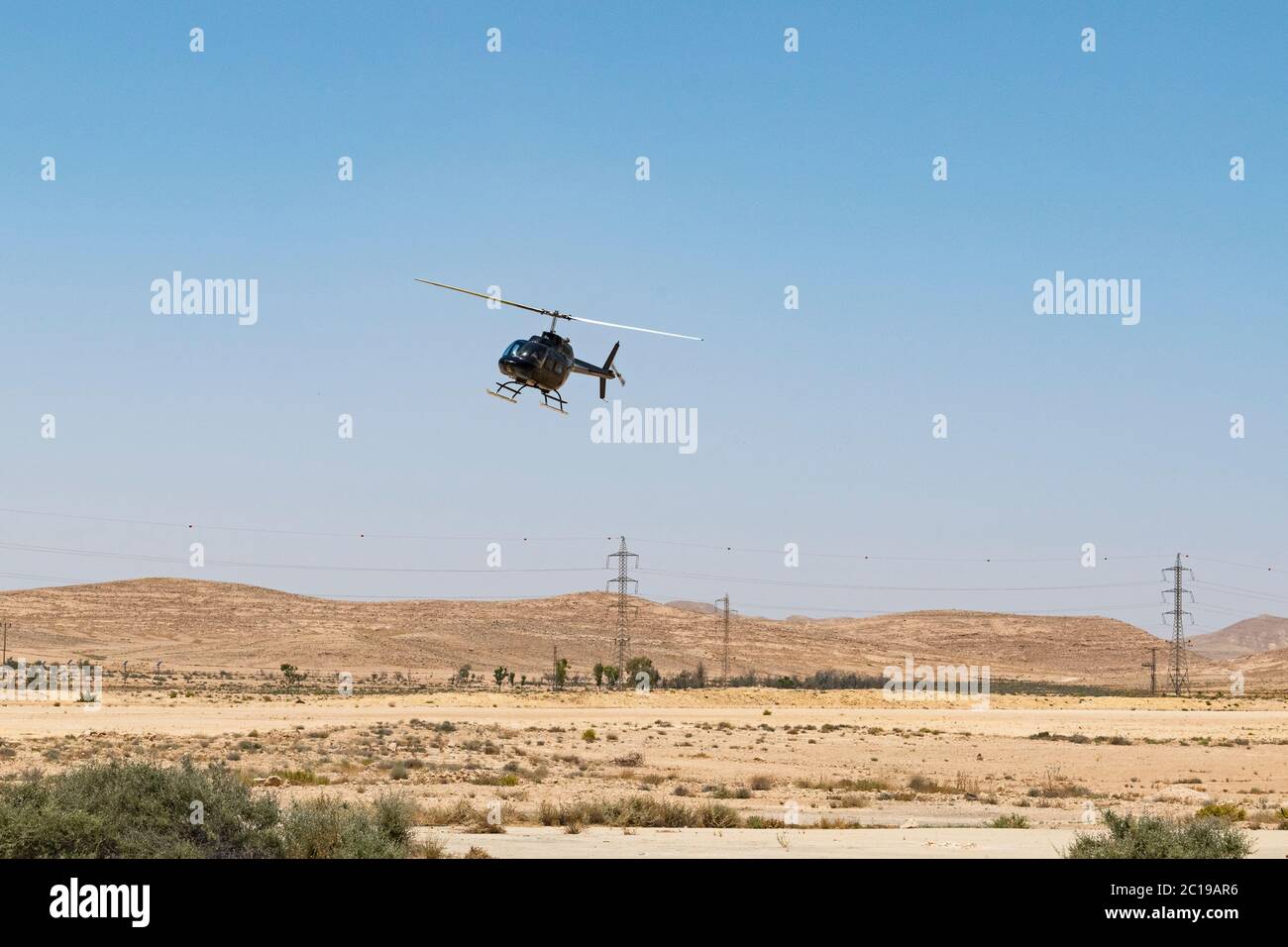 a small private tour helicopter landing in the negev desert near mitzpe ramon in israel to pick up tourists to fly over the makhtesh ramon crater Stock Photo