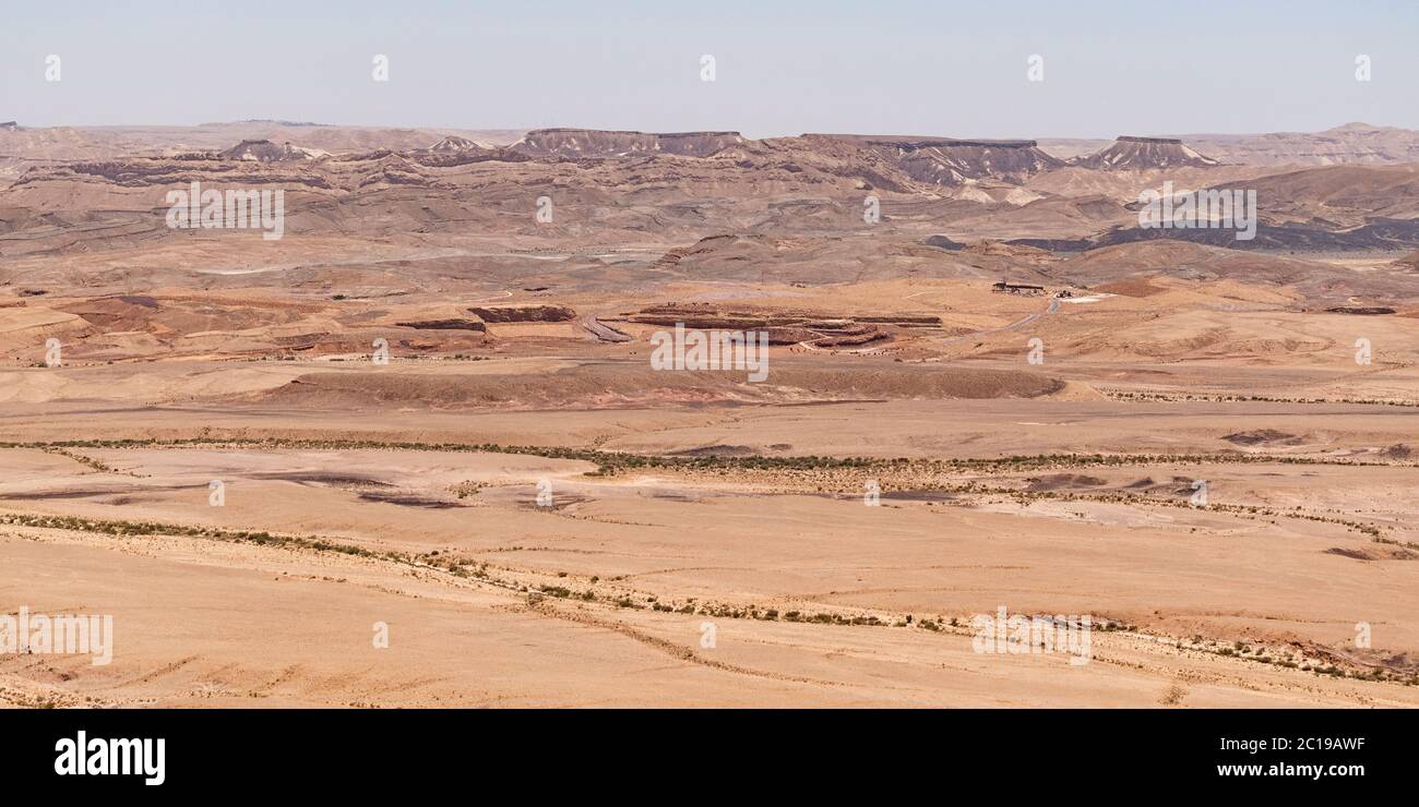 aerial panorama of the old quarries section of the bottom of the makhtesh ramon crater in israel with dry stream beds in the foreground Stock Photo