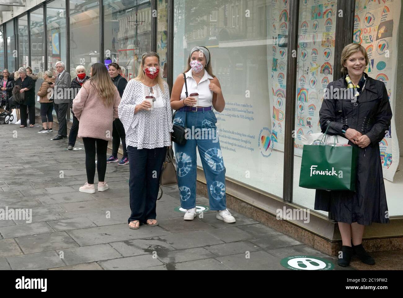 Shoppers wearing face masks as they queue to enter the Fenwick store in Northumberland Street, Newcastle, as non-essential shops in England open their doors to customers for the first time since coronavirus lockdown restrictions were imposed in March. Stock Photo
