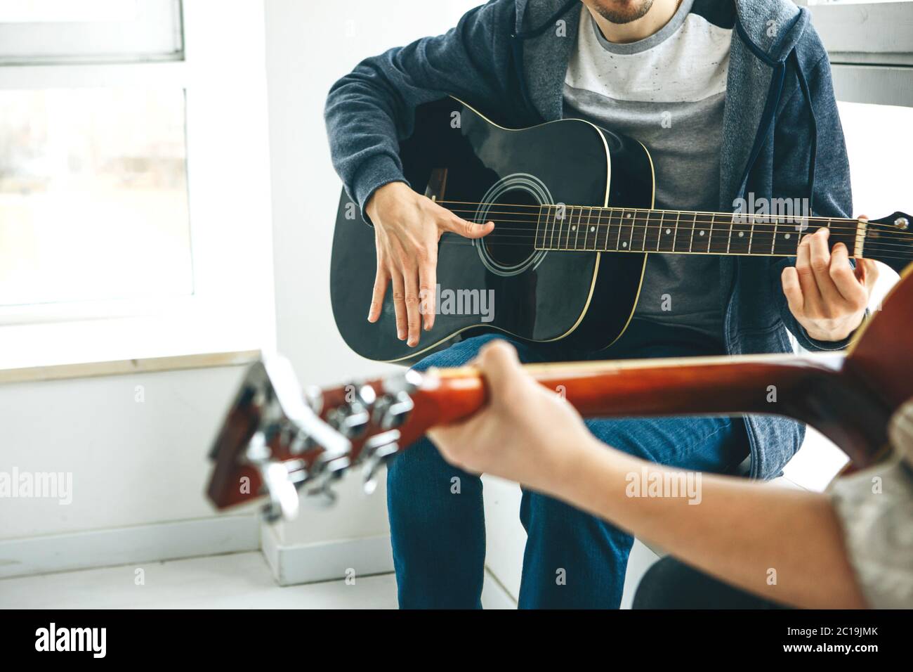Learning to play the guitar. The teacher explains to the student the