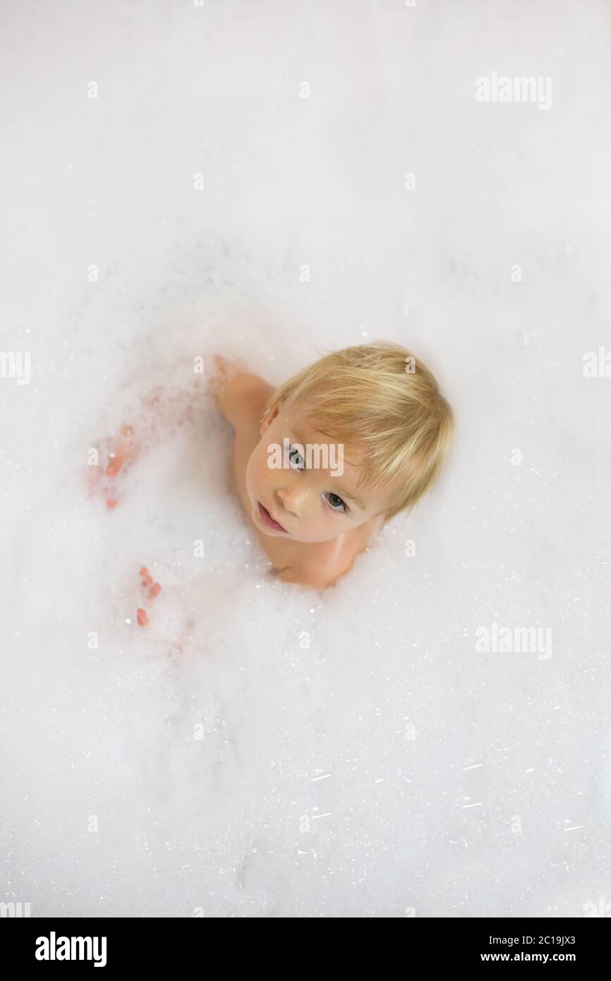 Little boy in bath in the bathroom. Child bathing with a lot of foam