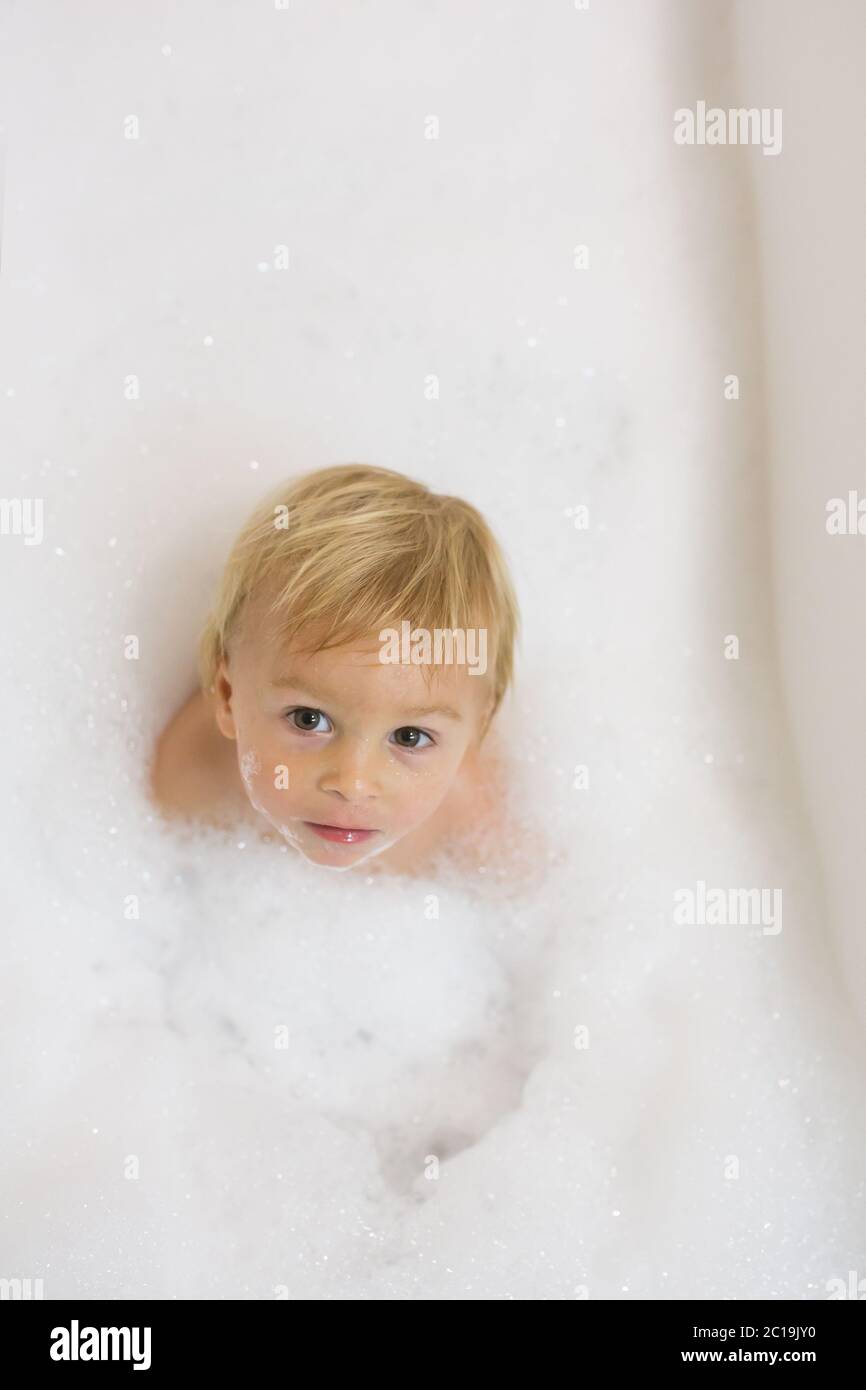 Little boy in bath in the bathroom. Child bathing with a lot of foam