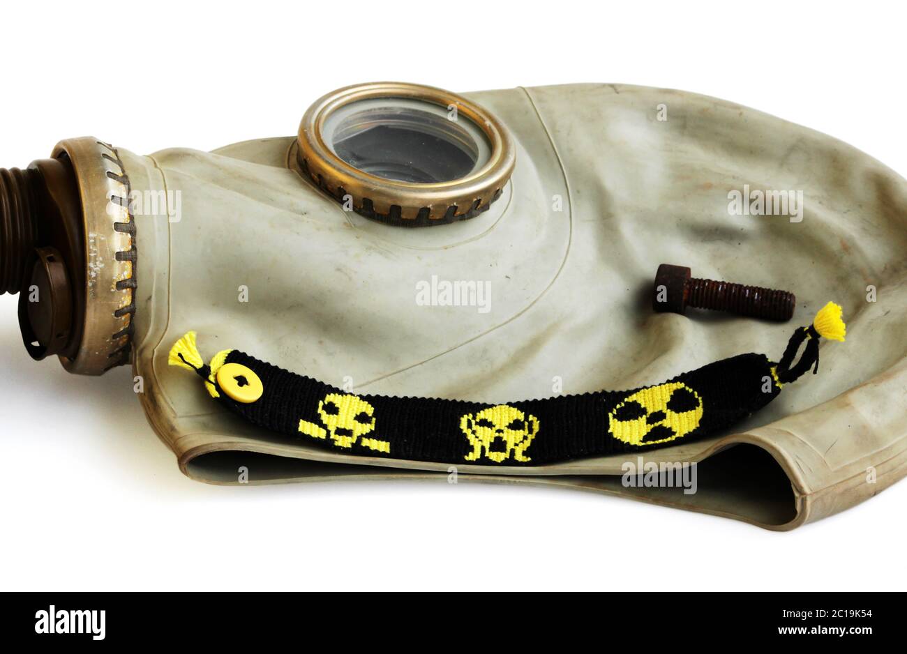 trophies of the stalker: old Russian gas mask, rusty nail and yellow-black baubles on a white background. Stock Photo