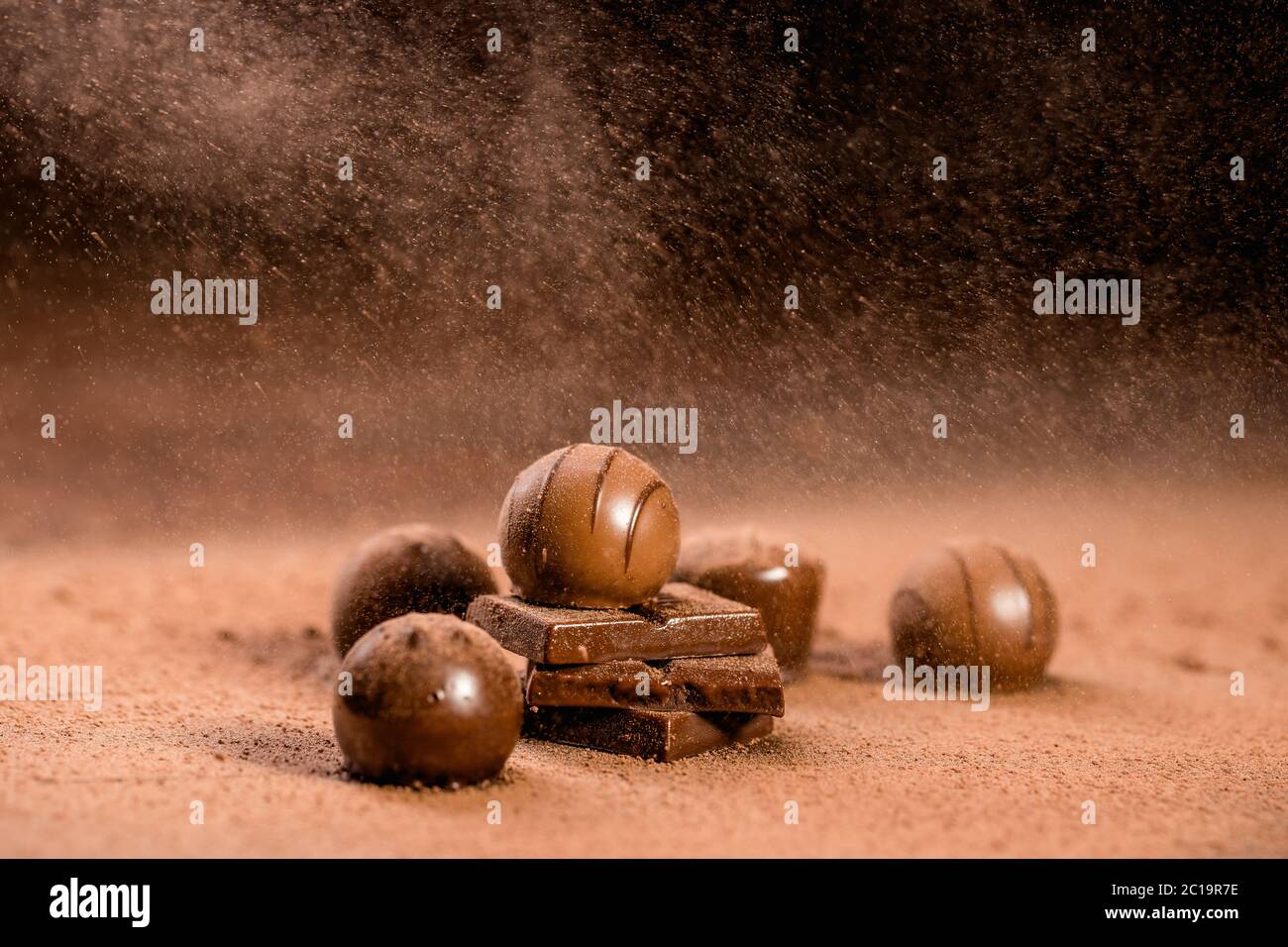 chocolate bars and pralines with sprinkle cocoa powder Stock Photo