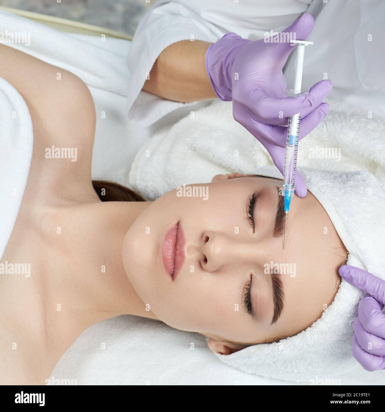 beautiful woman getting beauty injections into her forehead. beauty ...