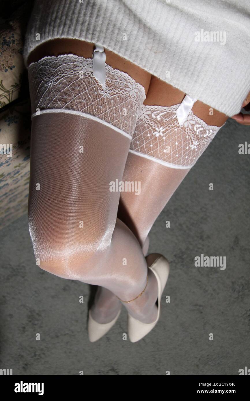 Legs covered from a pair of white stockings and white stiletto