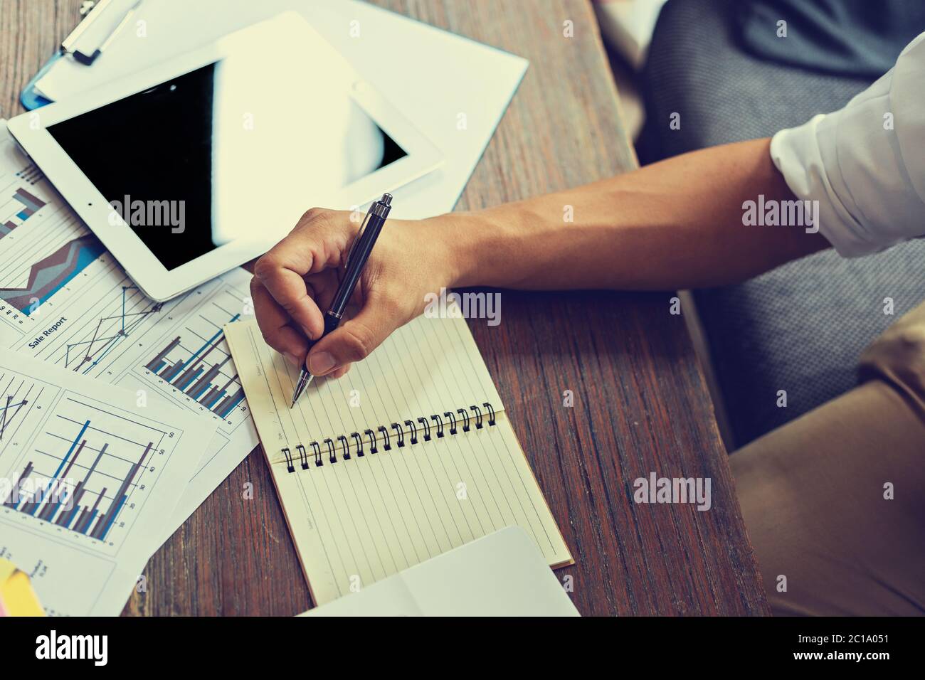 Businessman writing on paper graphs hi-res stock photography and images ...