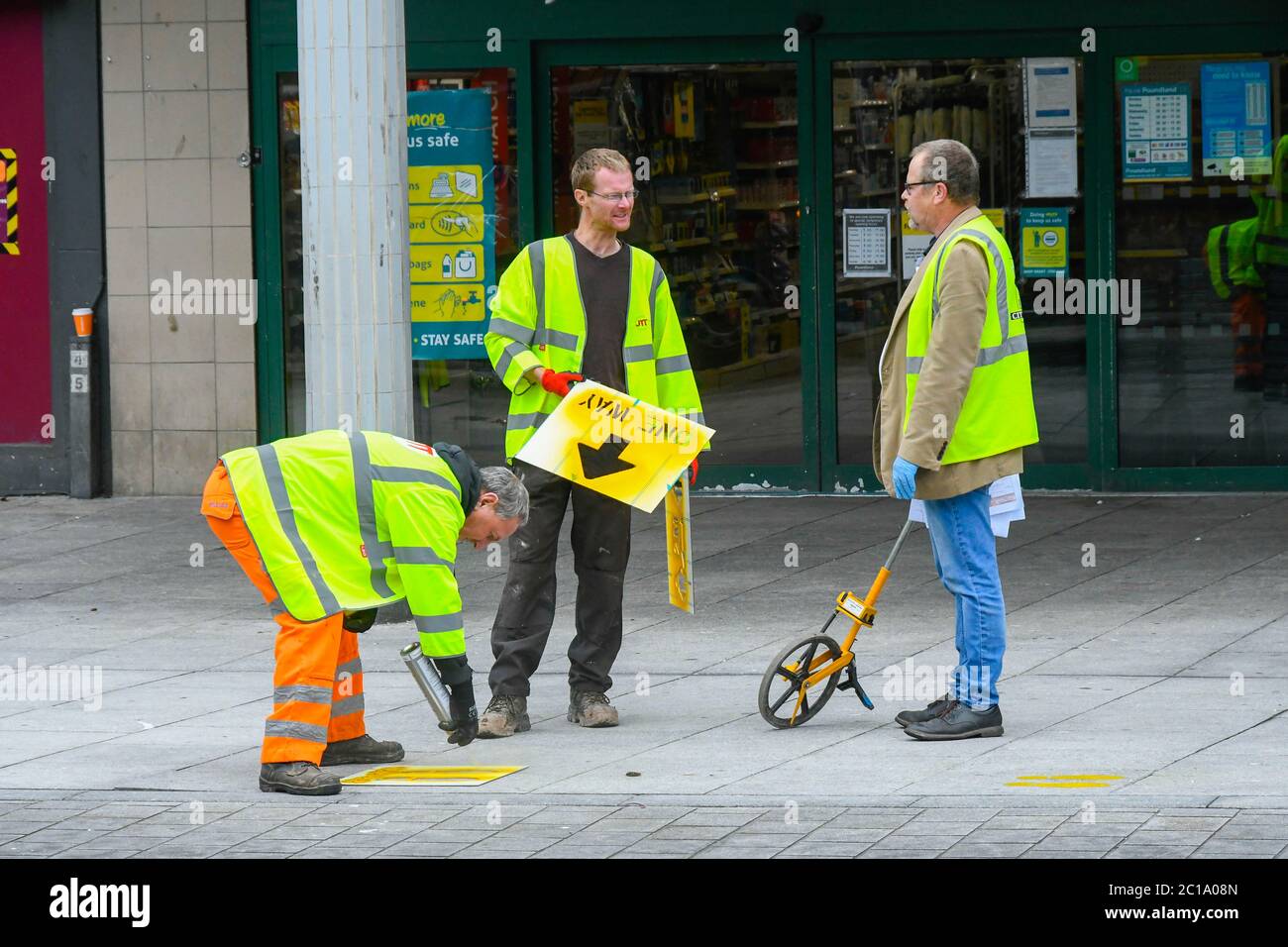 Exeter, Devon, UK.  15th June 2020.   Shops selling unessential items allowed to reopen today as coronavirus lockdown is eased further.  Council staff members painting social distancing and one way arrows on the pavement in the High Street at Exeter in Devon ahead of the reopening of the shops. Picture Credit: Graham Hunt/Alamy Live News Stock Photo