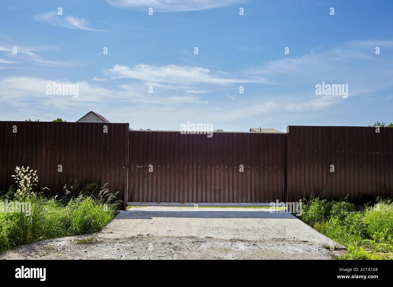 Metal fence of a house in suburb neighborhood. Rural landscape with sky ...