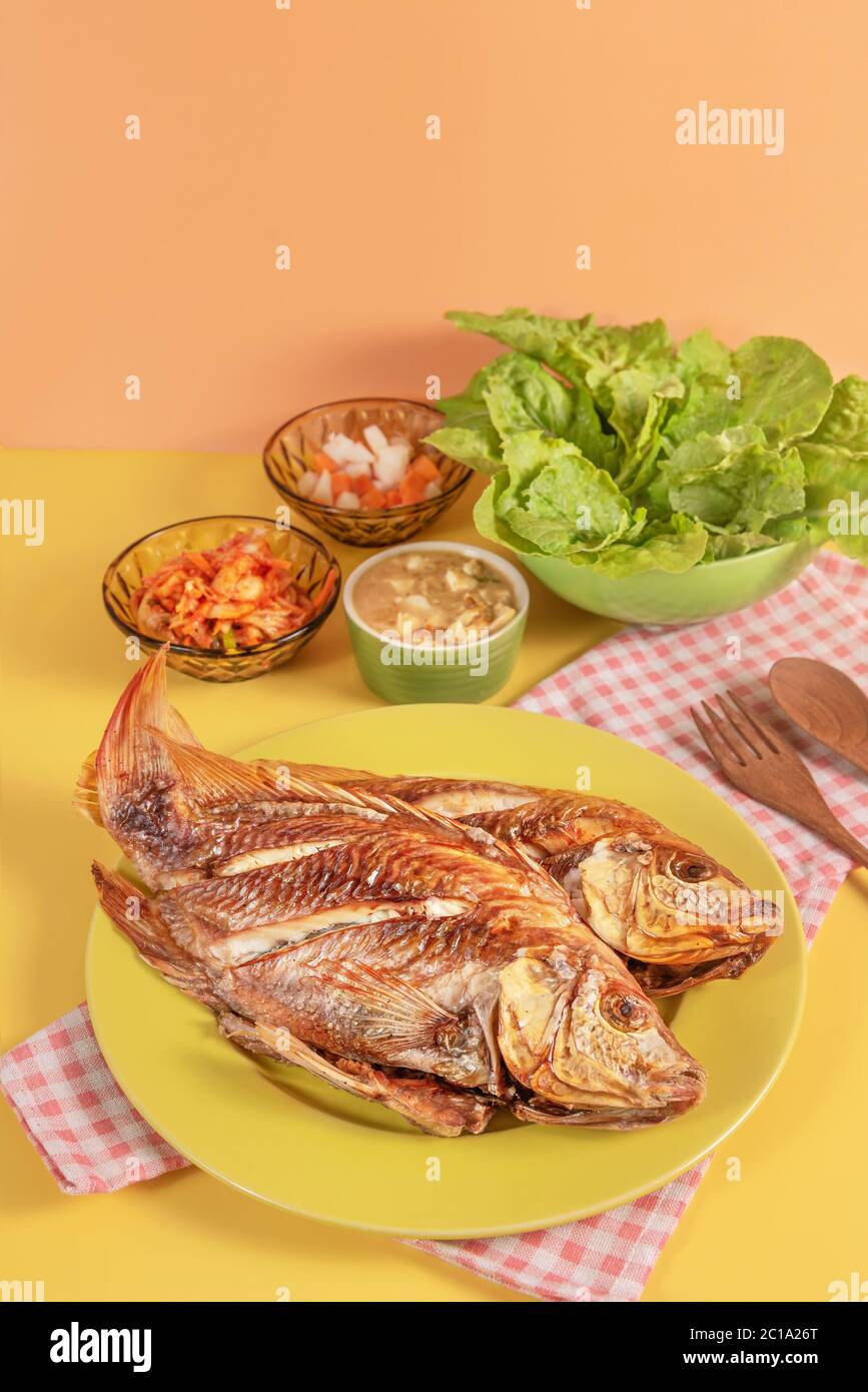 Fried fish dishes served with asian style sauce  , pickled vegetables and fresh lettuce Stock Photo