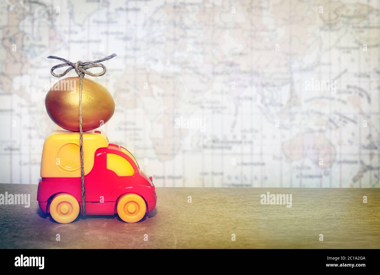 A toy truck carrying a golden egg, a symbol of the reliability of delivery of postal goods Stock Photo