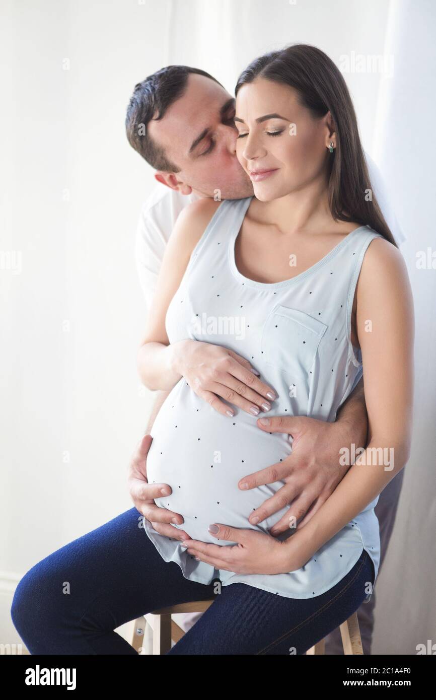 Pregnant woman and young man together indoors Stock Photo - Alamy