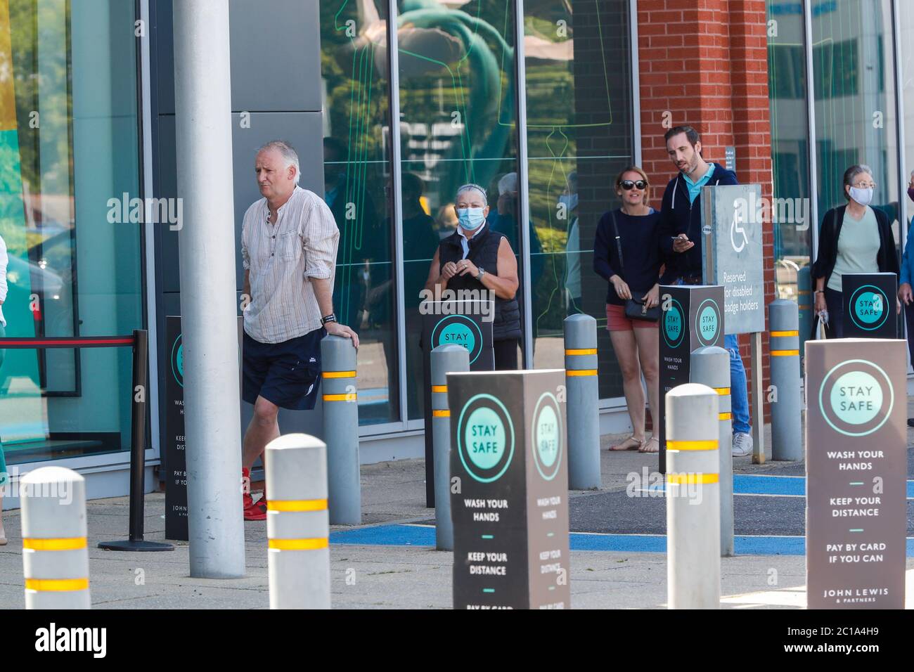 Bournemouth, UK. 15th June 2020. Shoppers queue outside the John Lewis