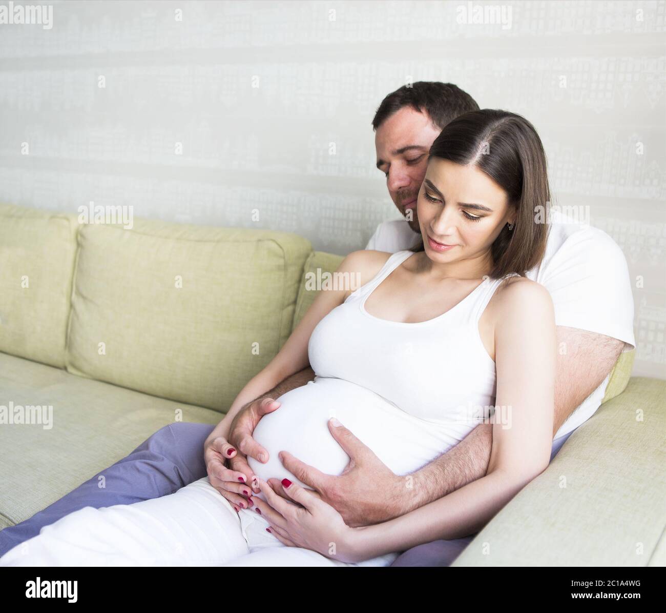 Pregnant woman and young man together indoors Stock Photo - Alamy