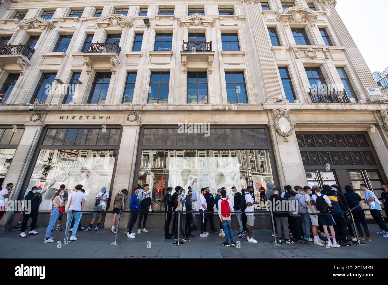 People queue outside Nike Town on Oxford Circus, London, as non-essential  shops in England open their doors to customers for the first time since  coronavirus lockdown restrictions were imposed in March Stock
