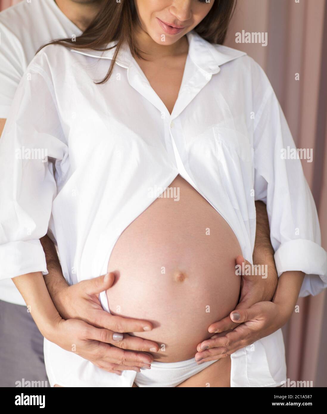 Pregnant woman and young man together indoors Stock Photo - Alamy