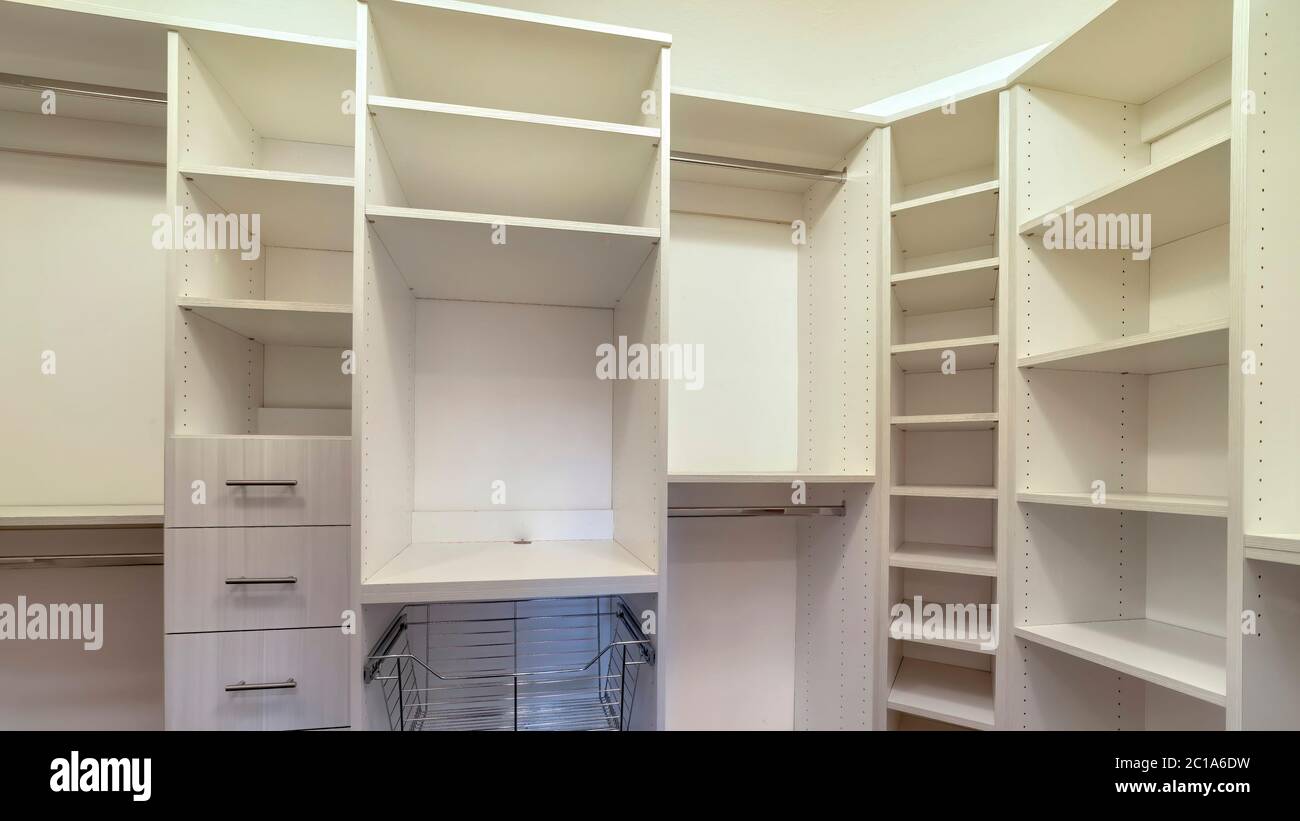 Panorama Walk in closet interior with shelves hanging rods drawers and