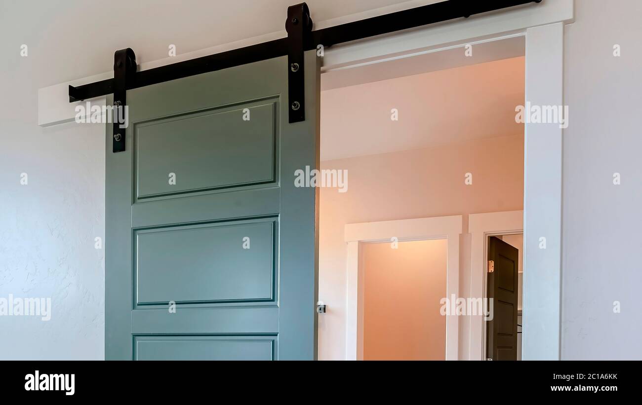 Panorama Sliding gray wooden panel door that leads to the bathroom of a ...