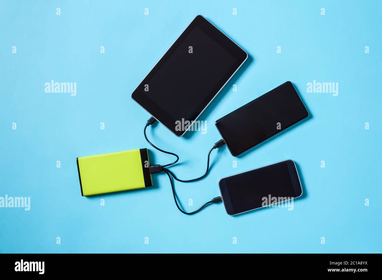 Tech Device Charge Sharing Two Mobile Phones And Tablet Charging From One Powerbank Battery Charger Flat Lay Top View On Blue Background Stock Photo Alamy