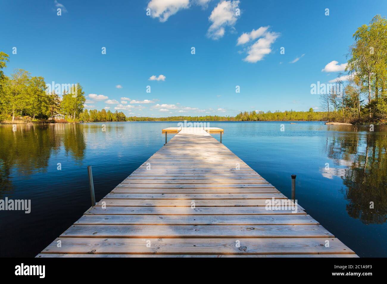 Deserted wooden jetty on a sunny day in the province of Smaland in Sweden Stock Photo