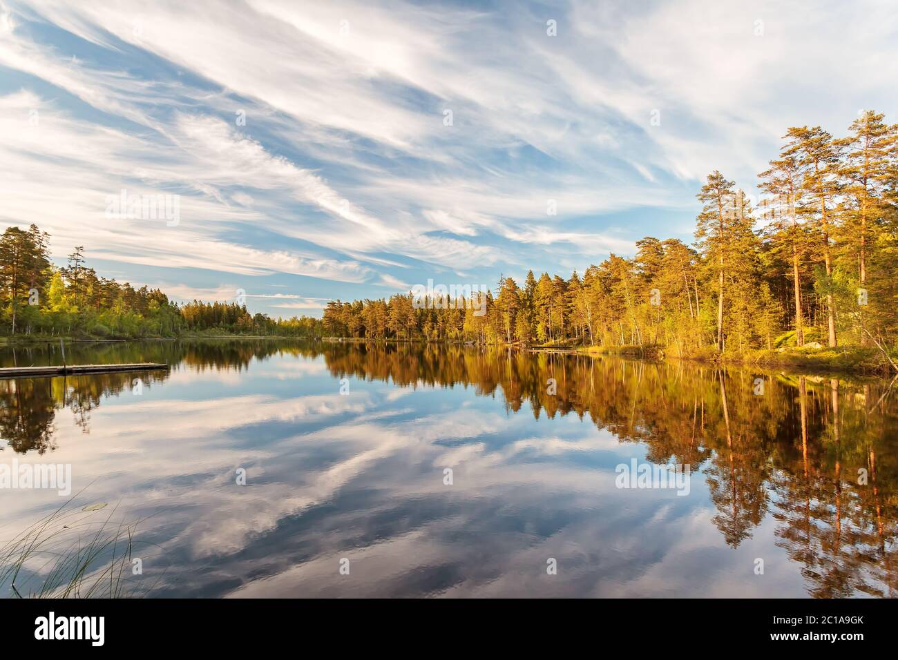 Reflections in a lake during early sunset in Smaland, Sweden Stock Photo