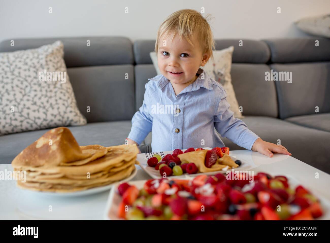 toddler-child-boy-eating-pancakes-with-lots-of-fruits-and-juice