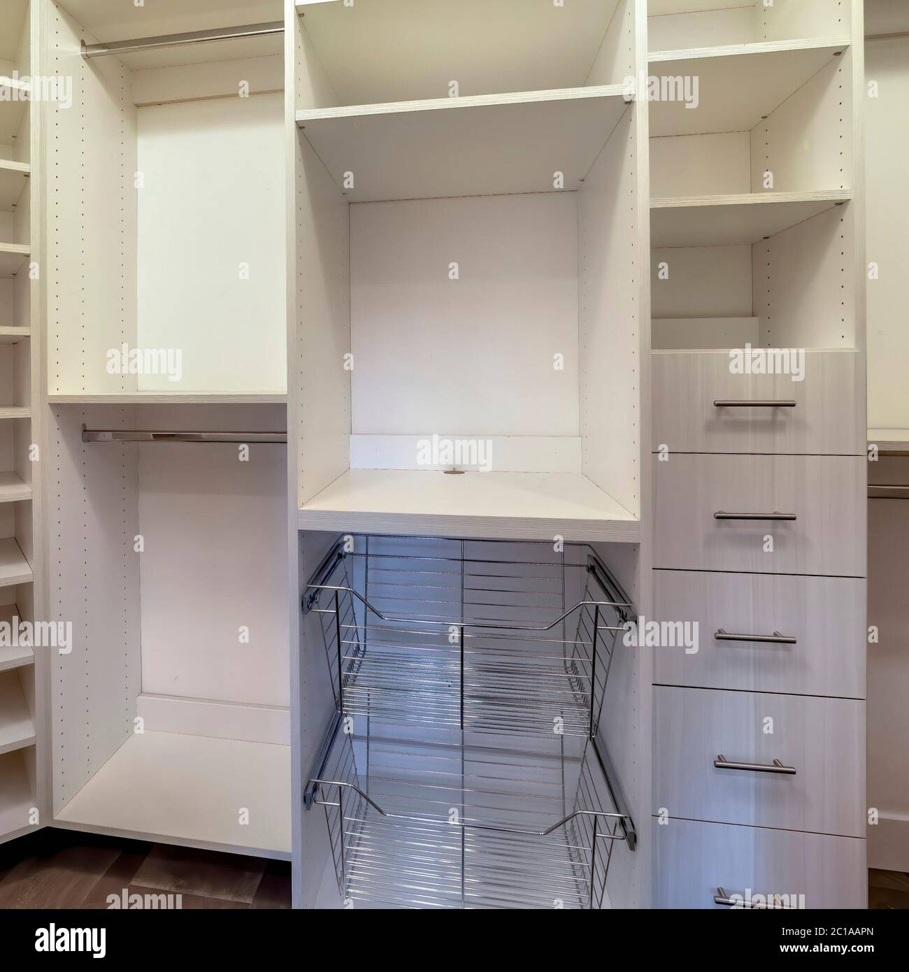 Square Walk in closet interior with shelves hanging rods drawers and