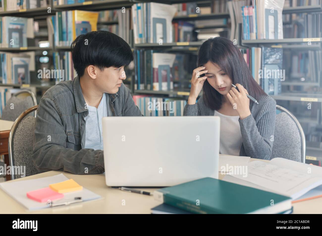 High school or college students  group catching up workbook and learning tutoring on desk and reading, doing homework, lesson practice preparing exam. Stock Photo