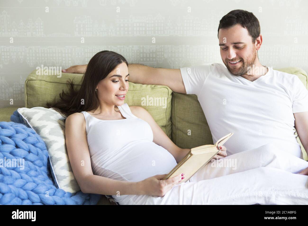 Pregnant woman and young man together indoors Stock Photo - Alamy
