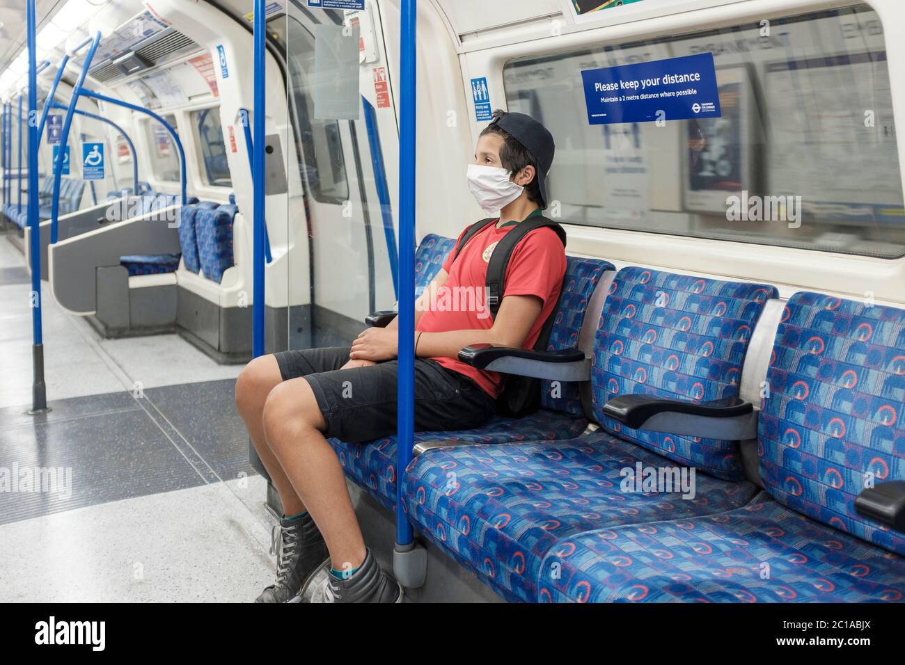 London, UK. 15th June, 2020. Coronavirus: Face coverings now mandatory on public transport.boy wearing a  face mask travels on London Undergound. Stock Photo