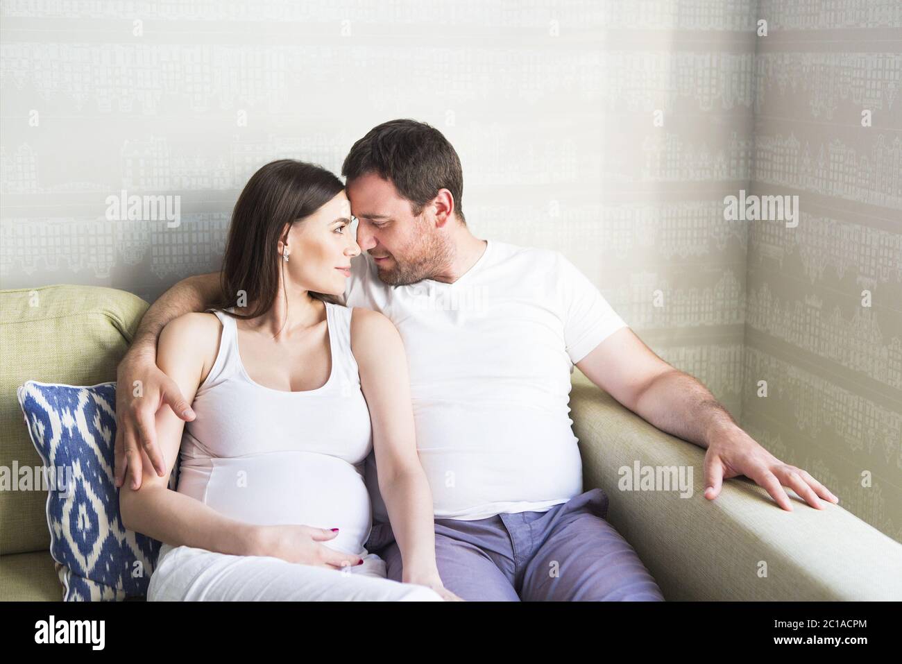 Pregnant woman and young man together indoors Stock Photo - Alamy