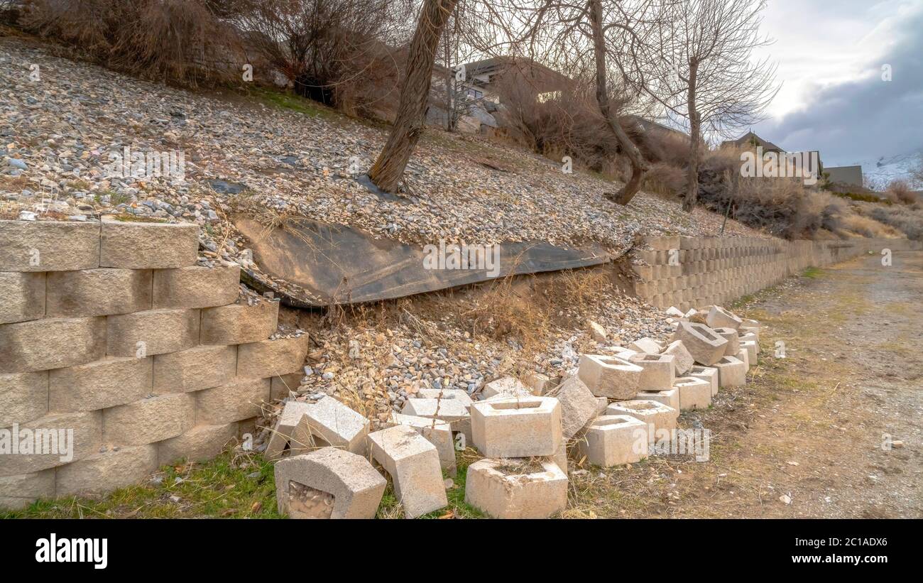 Panorama Conctere blocks of a collapsed low retaining wall lining a ...