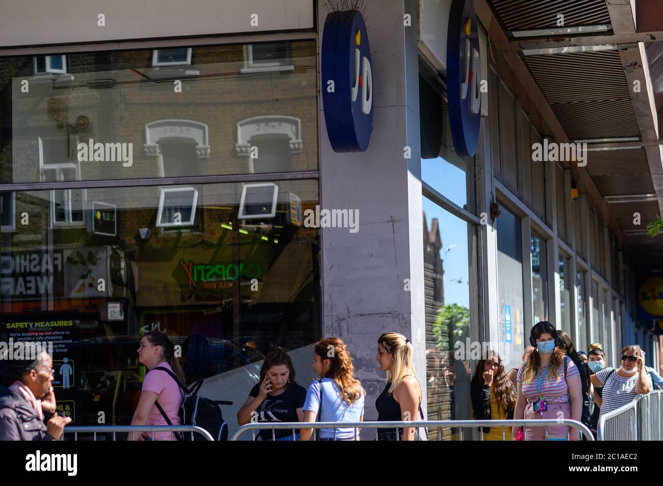 shoppers queue outside JD sports with Primark bags Stock Photo Alamy