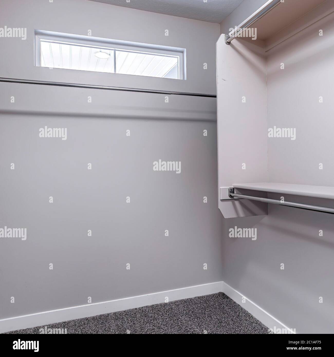 Square crop Hanging metal clothes rods inside empty closet interior of