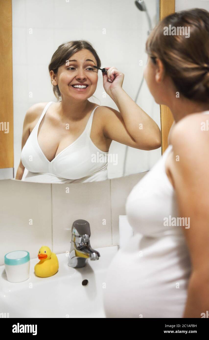 Young pregnant woman applying mascara Stock Photo