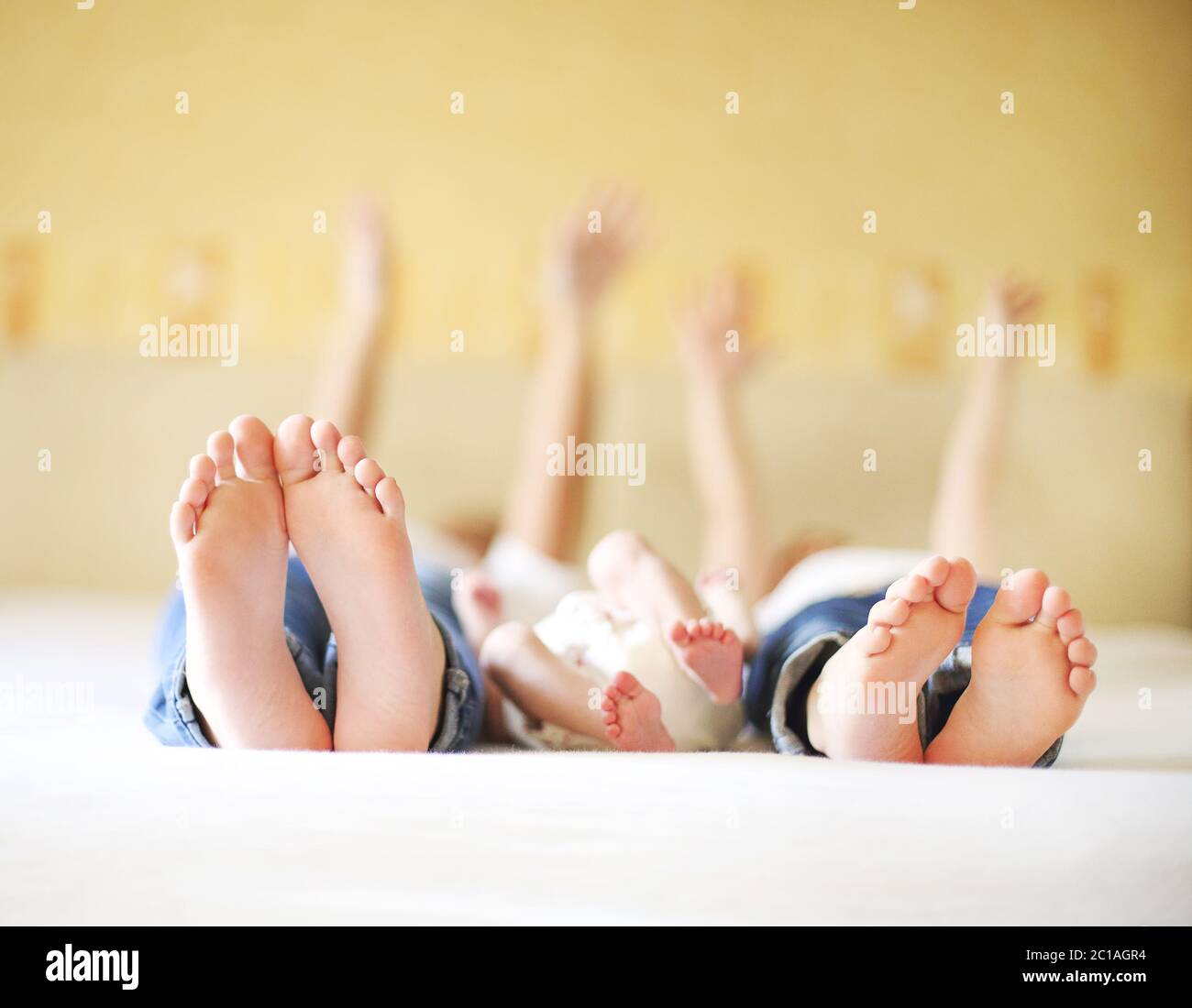 Sweet family in bed. Three sisters, close up on feet Stock Photo Alamy
