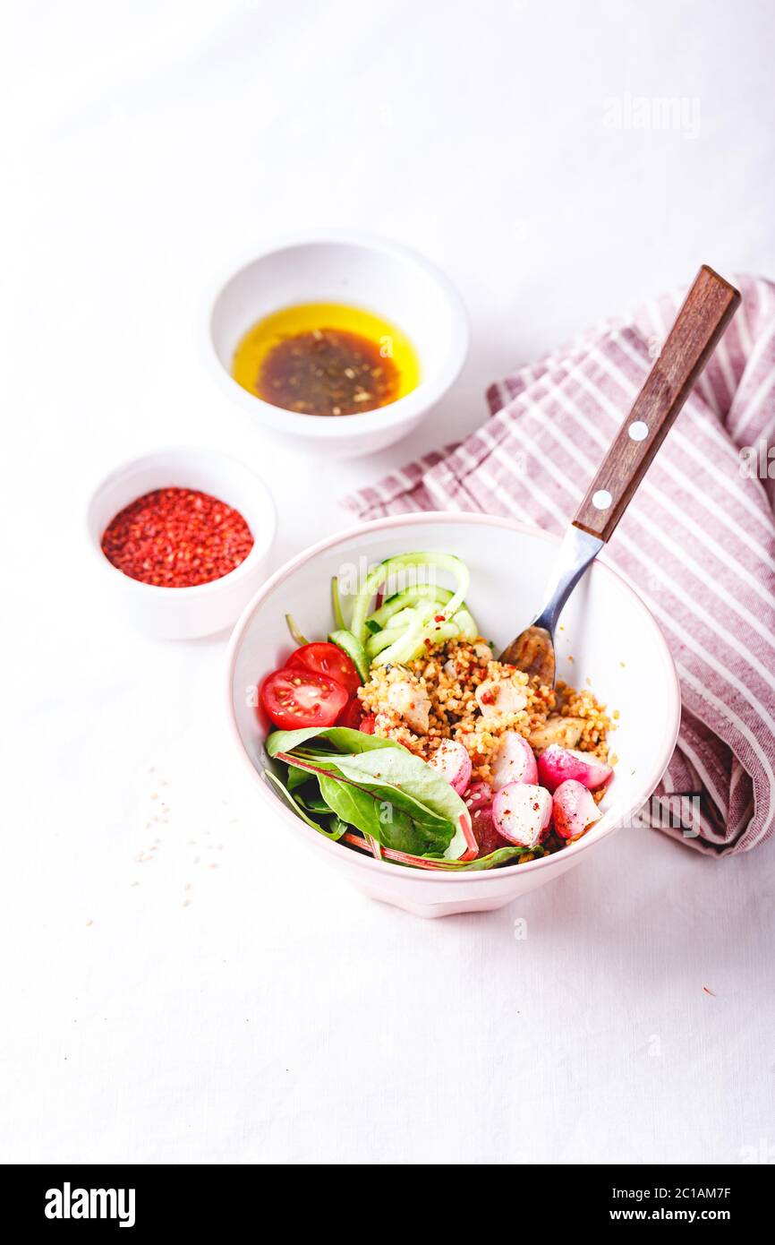 Salad with couscous, chicken, tomatoes, cucumber, roasted radish and